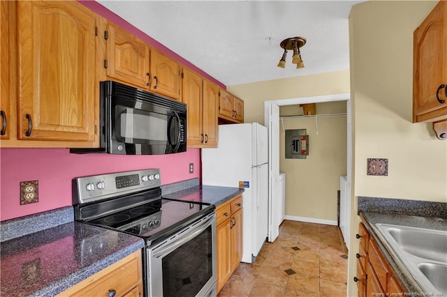 kitchen featuring stainless steel electric range oven, sink, electric panel, white fridge, and dark stone counters