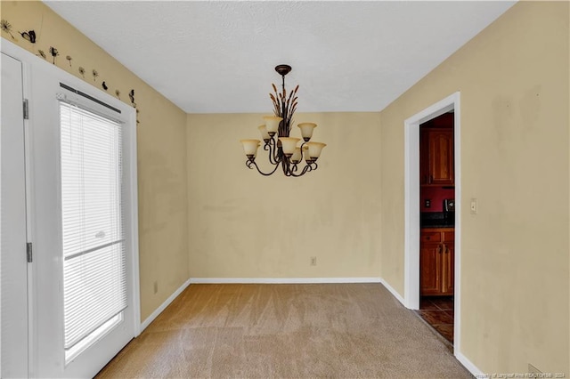 unfurnished room with carpet flooring and a chandelier