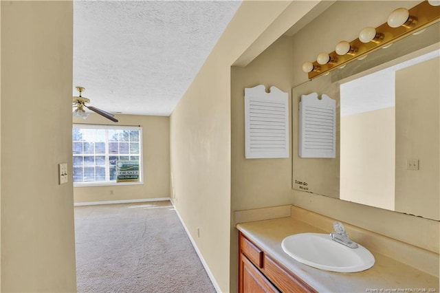 bathroom featuring ceiling fan, vanity, and a textured ceiling