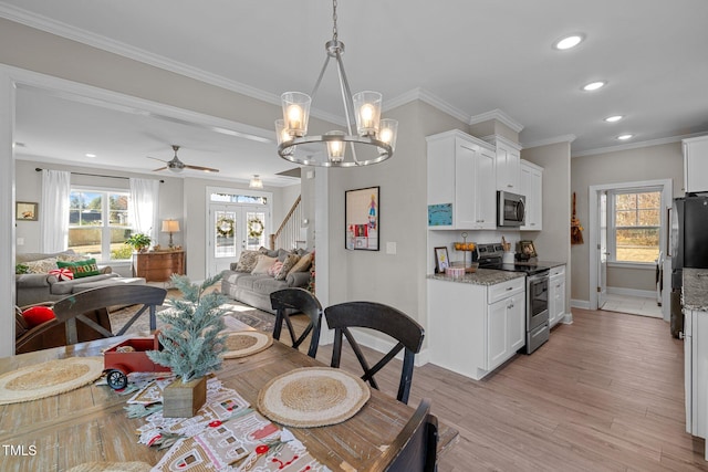 dining area with crown molding, a wealth of natural light, and light hardwood / wood-style flooring