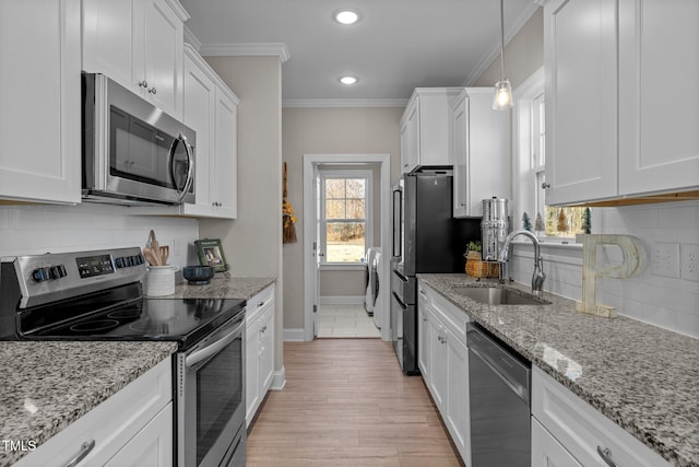 kitchen featuring stainless steel appliances, crown molding, sink, white cabinets, and light hardwood / wood-style floors