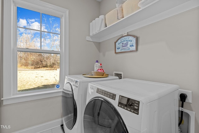 washroom with tile patterned floors, washer and dryer, and a healthy amount of sunlight