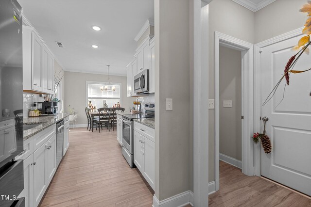 kitchen with white cabinetry, light stone counters, decorative backsplash, appliances with stainless steel finishes, and light wood-type flooring