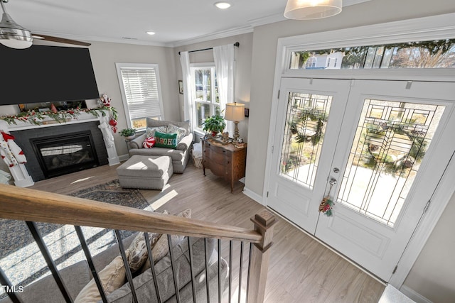 interior space with hardwood / wood-style flooring, ceiling fan, a healthy amount of sunlight, and ornamental molding