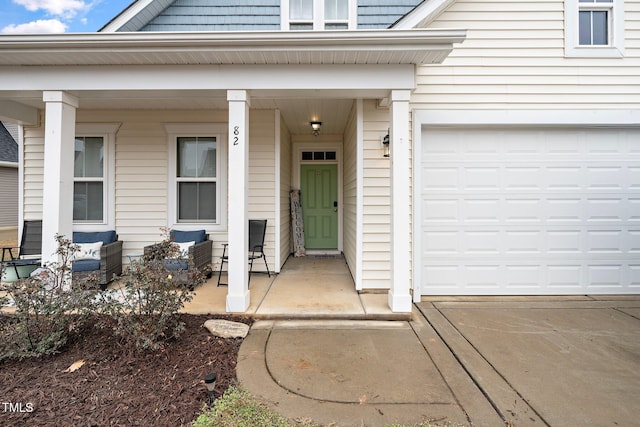 entrance to property with covered porch and a garage