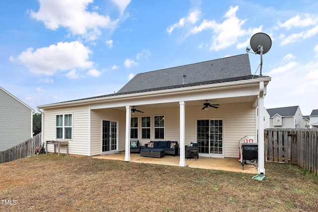 rear view of property featuring outdoor lounge area, ceiling fan, a patio area, and a lawn