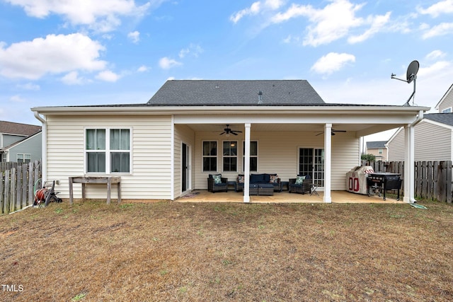 rear view of house with an outdoor living space, a patio, ceiling fan, and a lawn