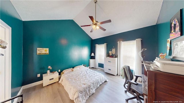 bedroom with ceiling fan, light wood-type flooring, and lofted ceiling