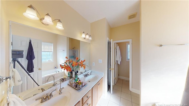 bathroom featuring tile patterned floors, vanity, and a tub