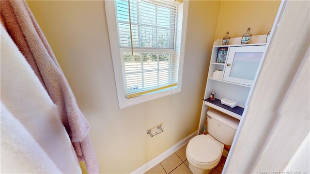 bathroom featuring a wealth of natural light, tile patterned flooring, and toilet