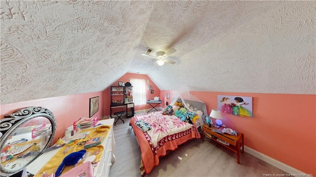 bedroom with a textured ceiling, ceiling fan, and lofted ceiling