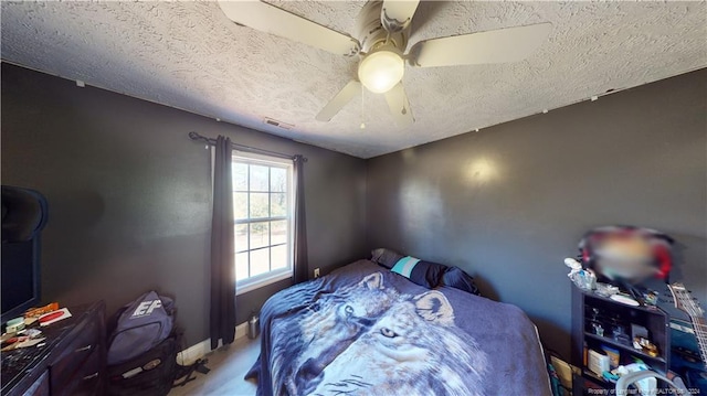 bedroom with ceiling fan and a textured ceiling