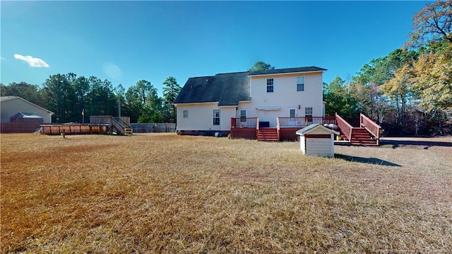 rear view of property featuring a yard and a deck