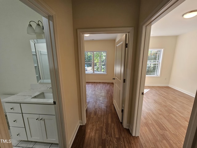 hallway with light hardwood / wood-style floors and a healthy amount of sunlight