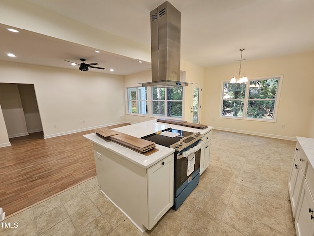 kitchen with island range hood, electric range, white cabinets, light hardwood / wood-style floors, and plenty of natural light