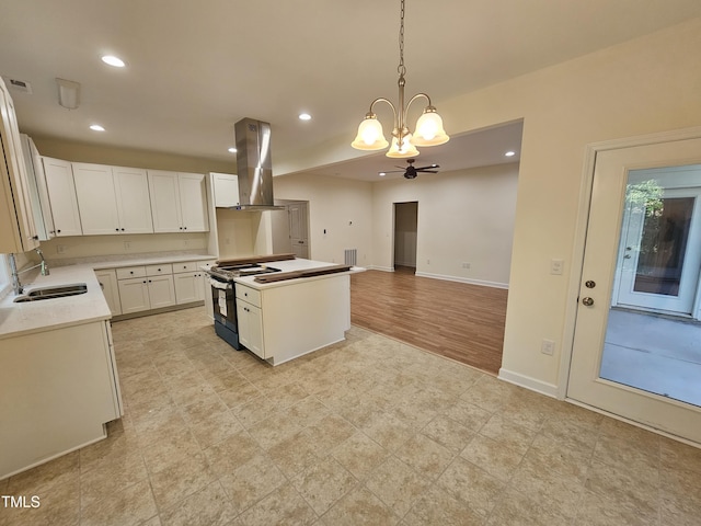 kitchen with extractor fan, sink, decorative light fixtures, black range, and white cabinets