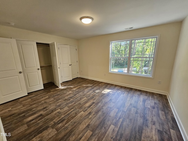 unfurnished bedroom with dark hardwood / wood-style flooring