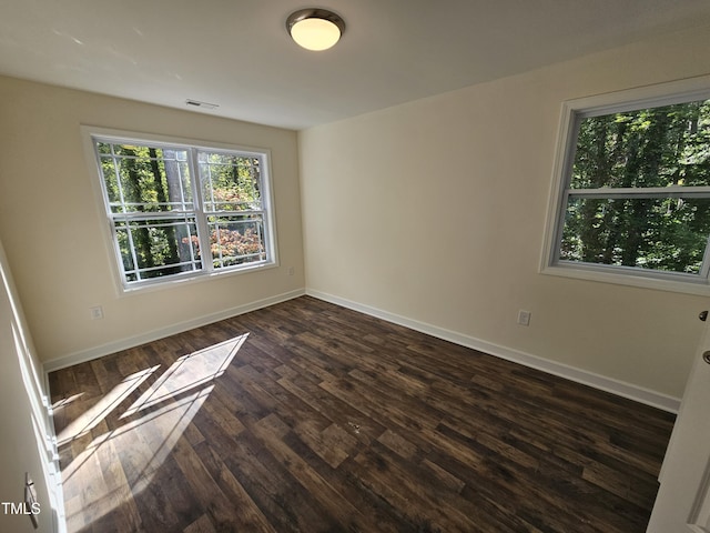 unfurnished room with dark hardwood / wood-style flooring