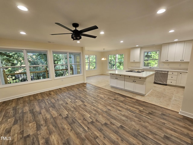 kitchen with dishwasher, a kitchen island, light hardwood / wood-style flooring, decorative light fixtures, and white cabinets