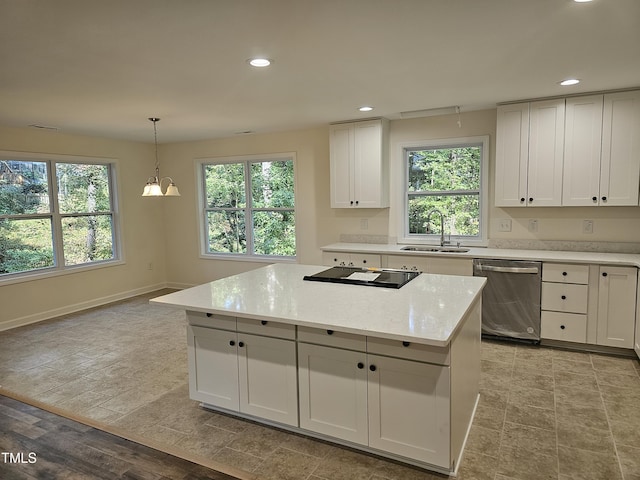 kitchen with sink, stainless steel dishwasher, decorative light fixtures, white cabinets, and light wood-type flooring