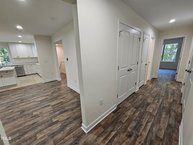 hall with plenty of natural light and dark hardwood / wood-style floors