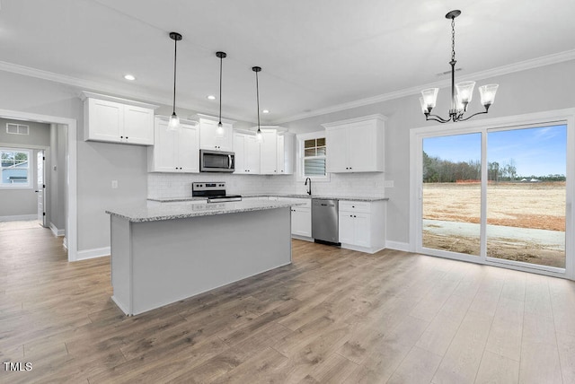 kitchen featuring pendant lighting, a center island, white cabinets, and appliances with stainless steel finishes