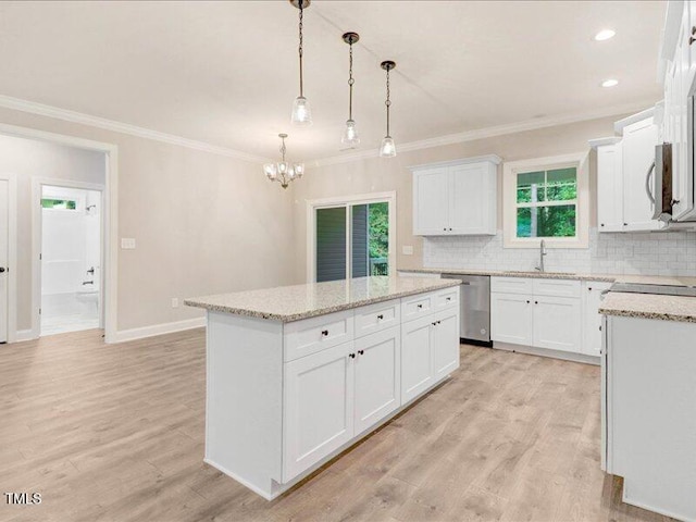 kitchen featuring white cabinets, sink, hanging light fixtures, a kitchen island, and stainless steel appliances