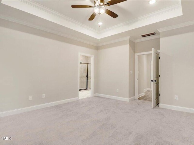 carpeted spare room with a raised ceiling, crown molding, and ceiling fan