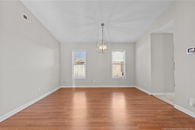 5814 Valhalla Ct, Fayetteville, NC 28304 - empty room with a chandelier, wood finished floors, baseboards, and vaulted ceiling