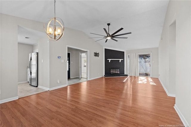 5814 Valhalla Ct, Fayetteville, NC 28304 - unfurnished living room with ceiling fan, light wood-style flooring, a chandelier, a brick fireplace, and vaulted ceiling
