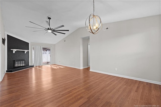 5814 Valhalla Ct, Fayetteville, NC 28304 - unfurnished living room with a chandelier, wood finished floors, a ceiling fan, lofted ceiling, and a brick fireplace