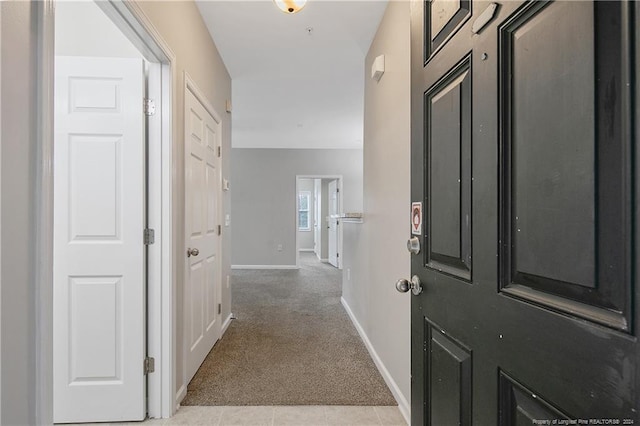 hallway featuring light colored carpet