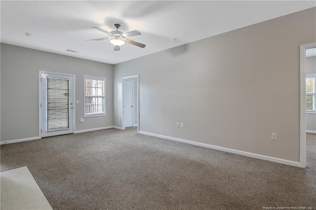 empty room featuring carpet, a wealth of natural light, and ceiling fan