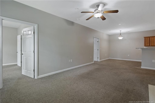 unfurnished living room featuring ceiling fan and dark colored carpet