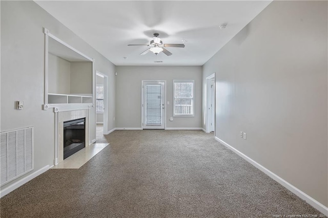 unfurnished living room with ceiling fan and a high end fireplace