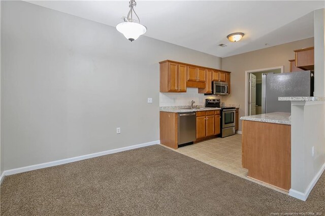 kitchen featuring pendant lighting, sink, stainless steel appliances, and light carpet