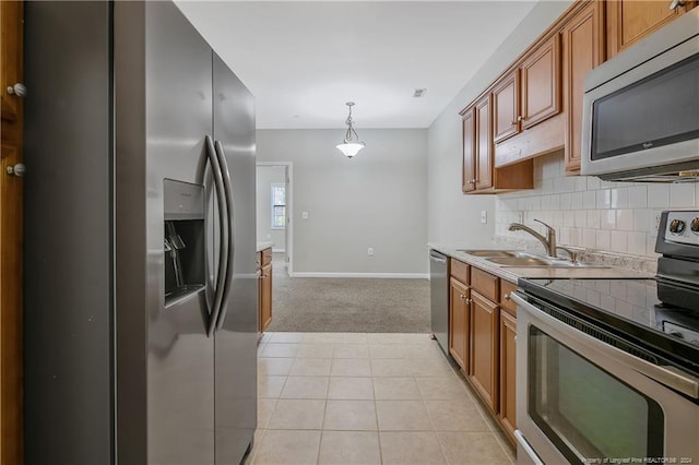 kitchen featuring pendant lighting, sink, light tile patterned floors, appliances with stainless steel finishes, and tasteful backsplash