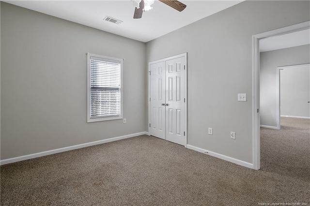 unfurnished bedroom featuring carpet, ceiling fan, and a closet