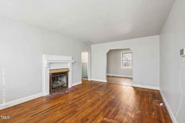 unfurnished living room with a textured ceiling and hardwood / wood-style floors