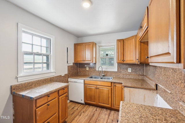 kitchen with light hardwood / wood-style flooring, sink, tasteful backsplash, white dishwasher, and light stone counters