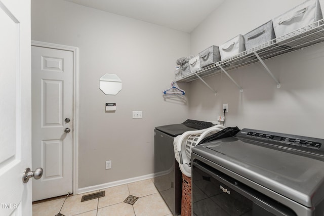 laundry area featuring separate washer and dryer and light tile patterned floors