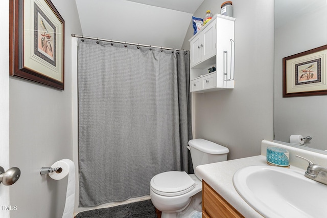 bathroom with vanity, toilet, and lofted ceiling