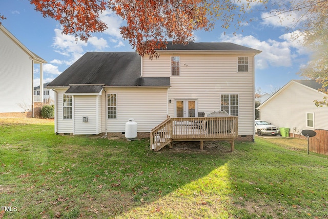 rear view of house featuring a yard, a wooden deck, and french doors