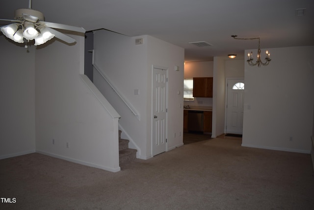 unfurnished living room with carpet and ceiling fan with notable chandelier