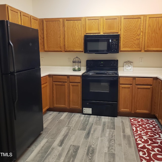 kitchen featuring black appliances and hardwood / wood-style flooring