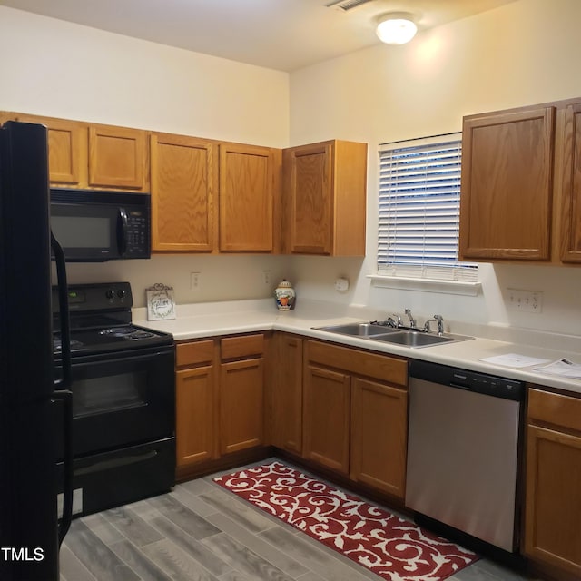 kitchen featuring black appliances, sink, and hardwood / wood-style floors