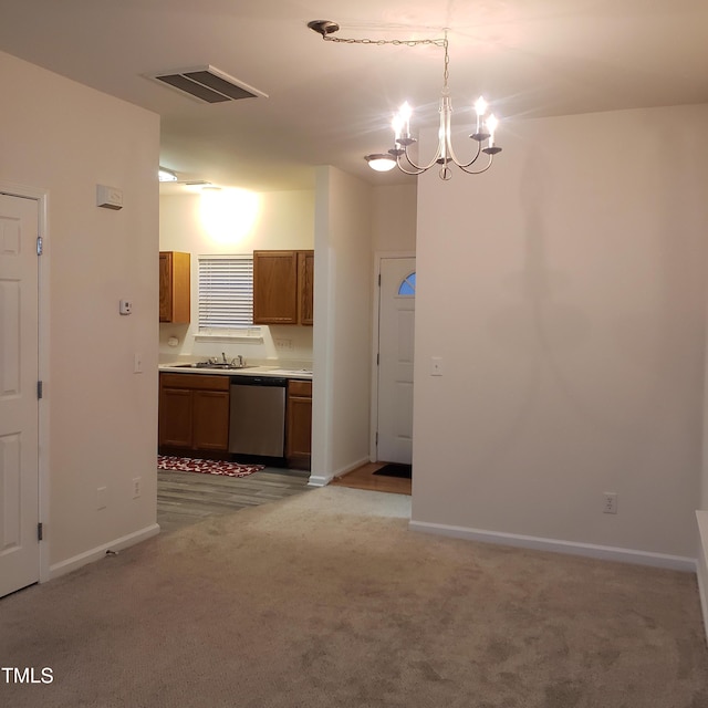 interior space featuring light colored carpet, sink, a notable chandelier, dishwasher, and hanging light fixtures