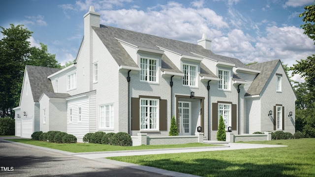 view of front of house featuring brick siding, a chimney, and a front yard