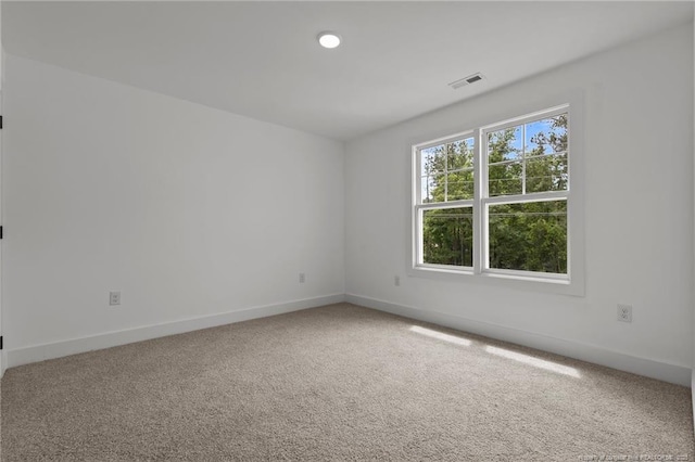 carpeted spare room with baseboards and visible vents