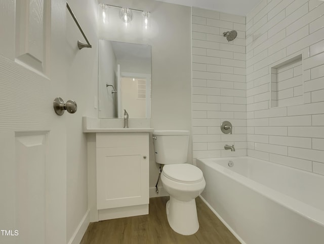 full bathroom with vanity, wood-type flooring, tiled shower / bath combo, and toilet